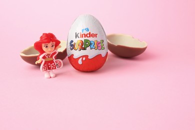 Photo of Slynchev Bryag, Bulgaria - May 25, 2023: Kinder Surprise Eggs and toy on pink background, space for text