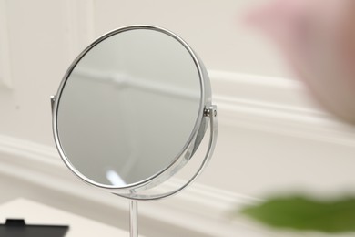 Photo of Mirror and flowers on dressing table, closeup