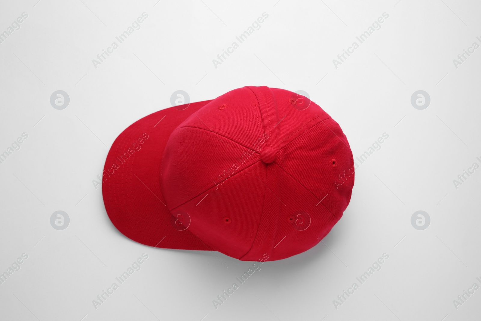 Photo of Stylish red baseball cap on white background, top view