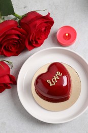 Photo of St. Valentine's Day. Delicious heart shaped cake and roses on light table, flat lay
