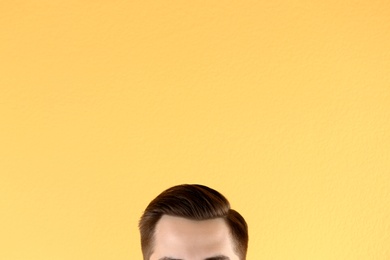 Man with beautiful hair on color background, closeup