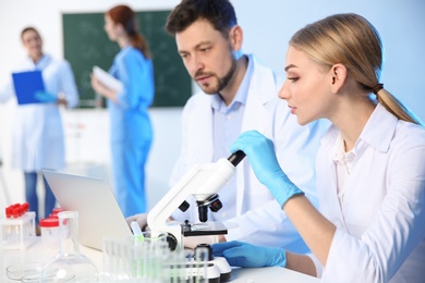 Group of scientists working in modern chemistry laboratory