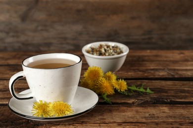 Photo of Delicious fresh dandelion tea on wooden table. Space for text