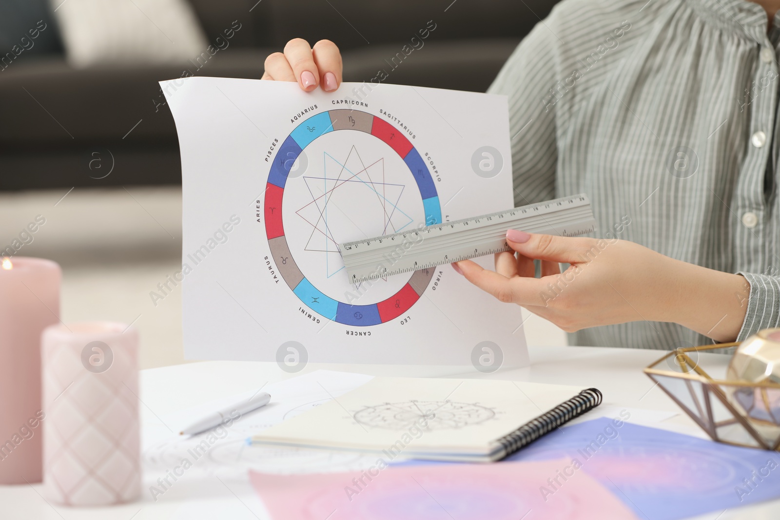 Photo of Astrologer using zodiac wheel for fate forecast at table, closeup. Fortune telling