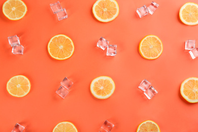 Lemonade layout with juicy lemon slices and ice cubes on coral background, top view