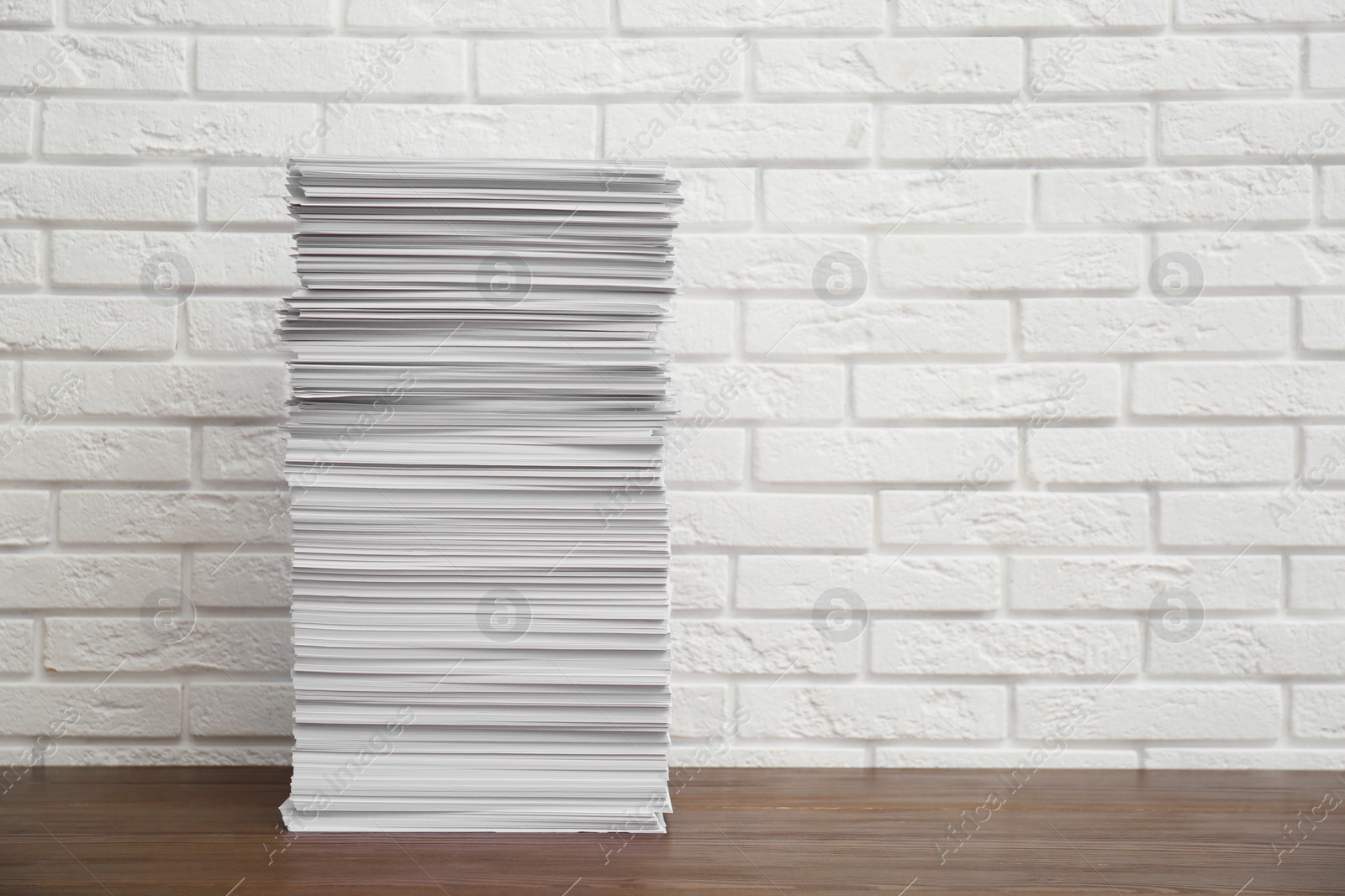 Photo of Stack of paper sheets on wooden table. Space for text