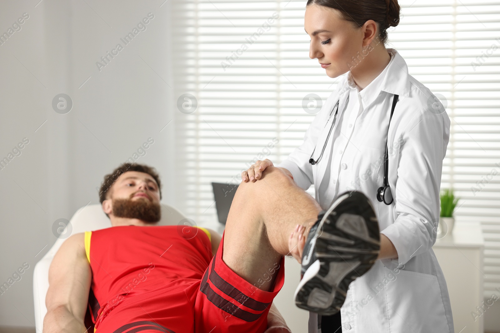 Photo of Sports injury. Doctor examining patient's leg in hospital