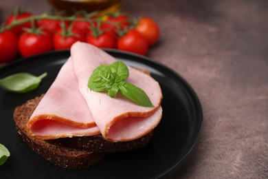 Photo of Delicious sandwich with ham on brown table, closeup