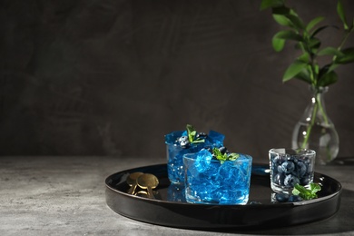 Tray with glasses of jelly on table against dark background. Space for text