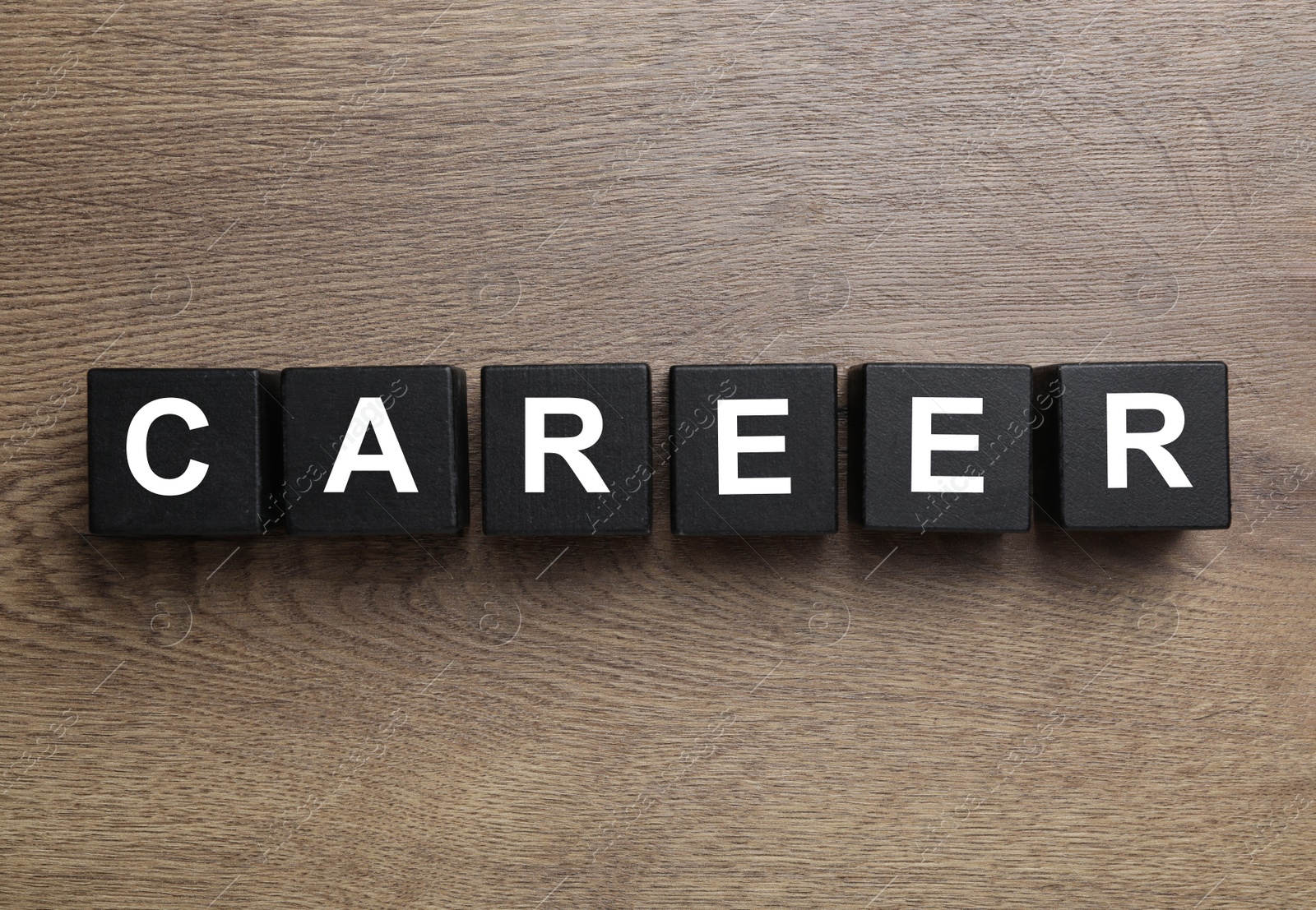 Photo of Black cubes with word CAREER on wooden background, flat lay