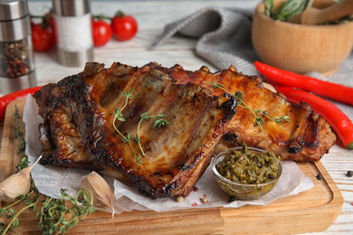 Photo of Tasty aromatic grilled ribs with thyme served on table