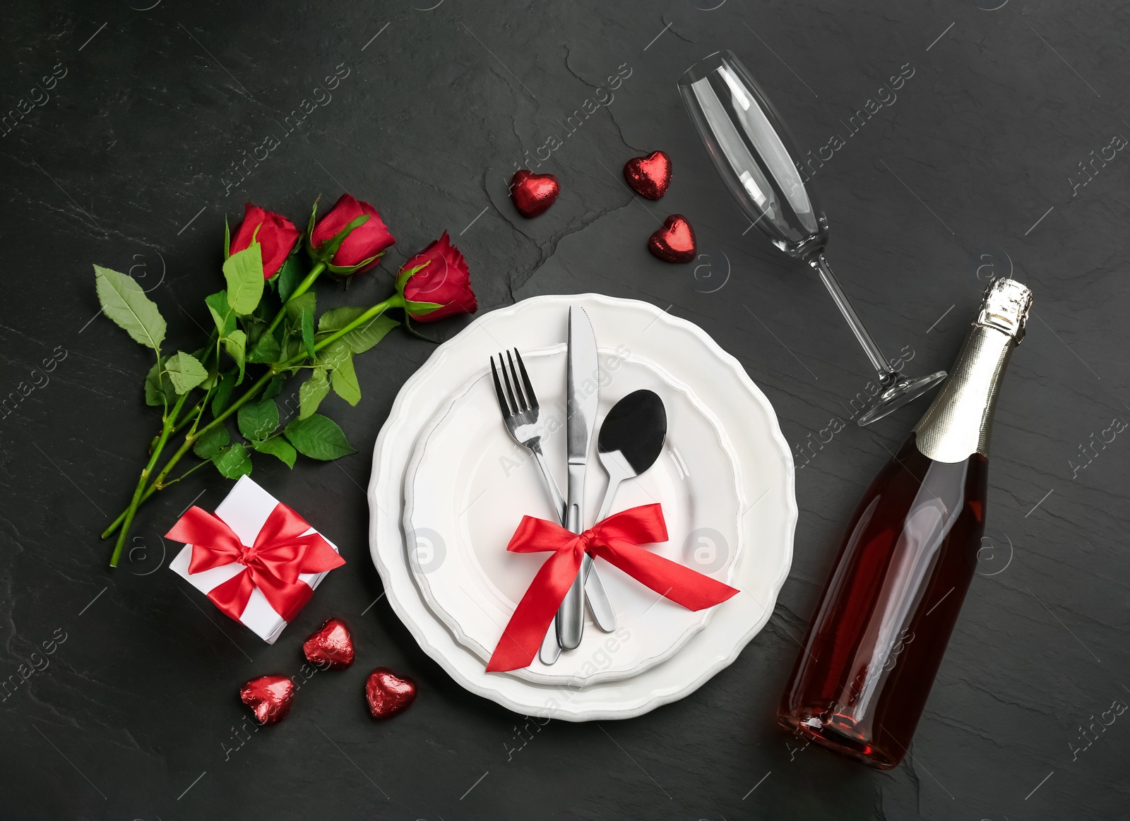 Photo of Beautiful table setting for Valentine's Day dinner on black background, flat lay