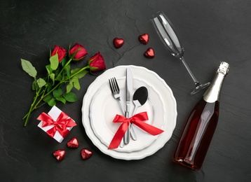 Photo of Beautiful table setting for Valentine's Day dinner on black background, flat lay