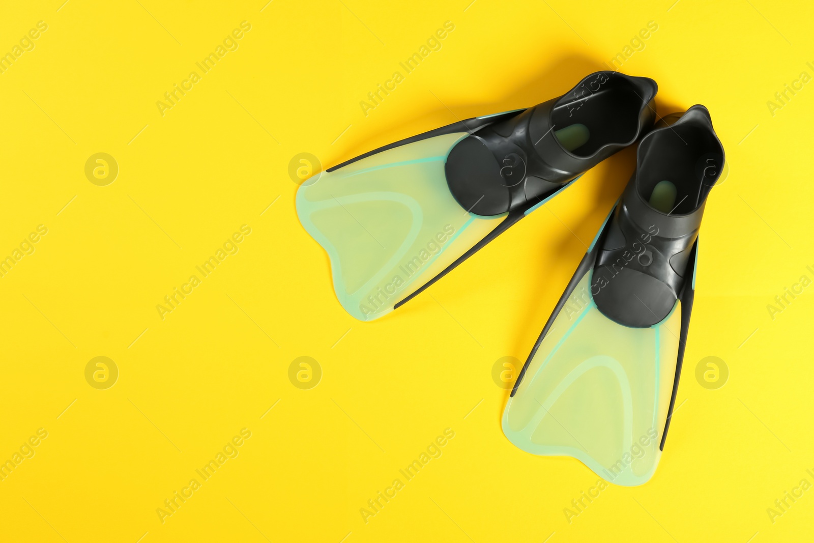 Photo of Swimming flippers on color background, top view. Space for text