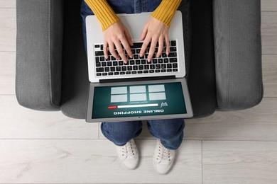 Woman using laptop for online shopping in armchair indoors, top view