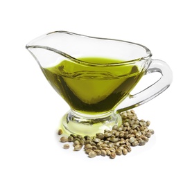 Photo of Gravy boat with hemp oil and seeds on white background