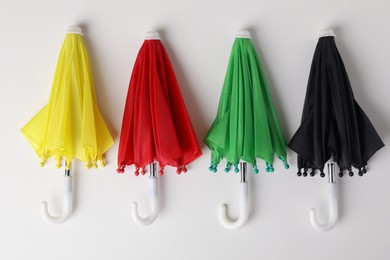 Photo of Small color umbrellas on white background, top view