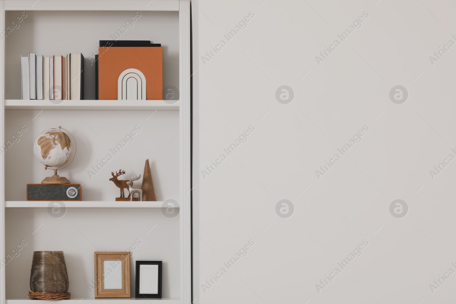 Photo of Stylish shelves with different decor elements indoors, space for text. Interior design