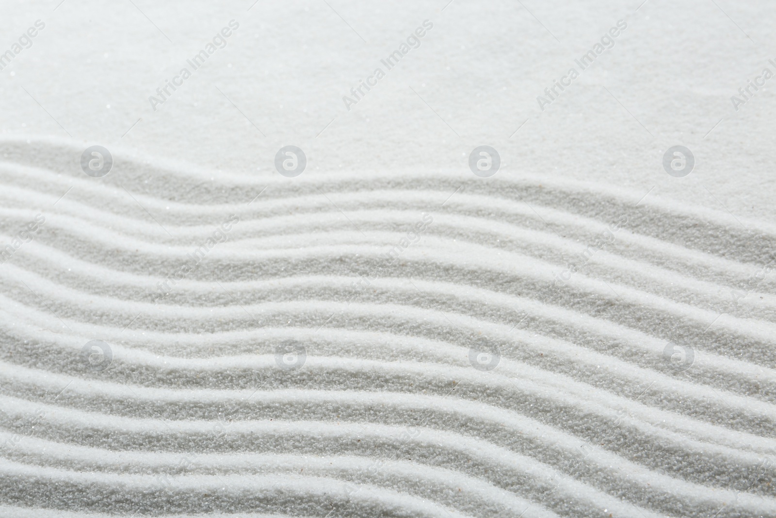 Photo of Zen rock garden. Wave pattern on white sand, closeup