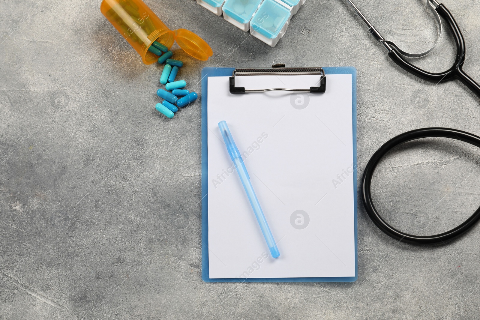 Photo of Endocrinology. Flat lay composition with clipboard and model of thyroid gland on grey table, space for text