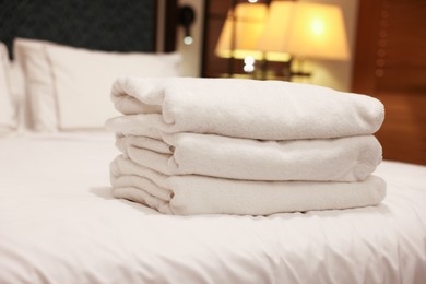 Photo of Stacked towels on bed in hotel room