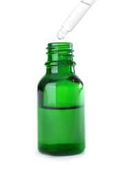 Dropping herbal essential oil into bottle isolated on white