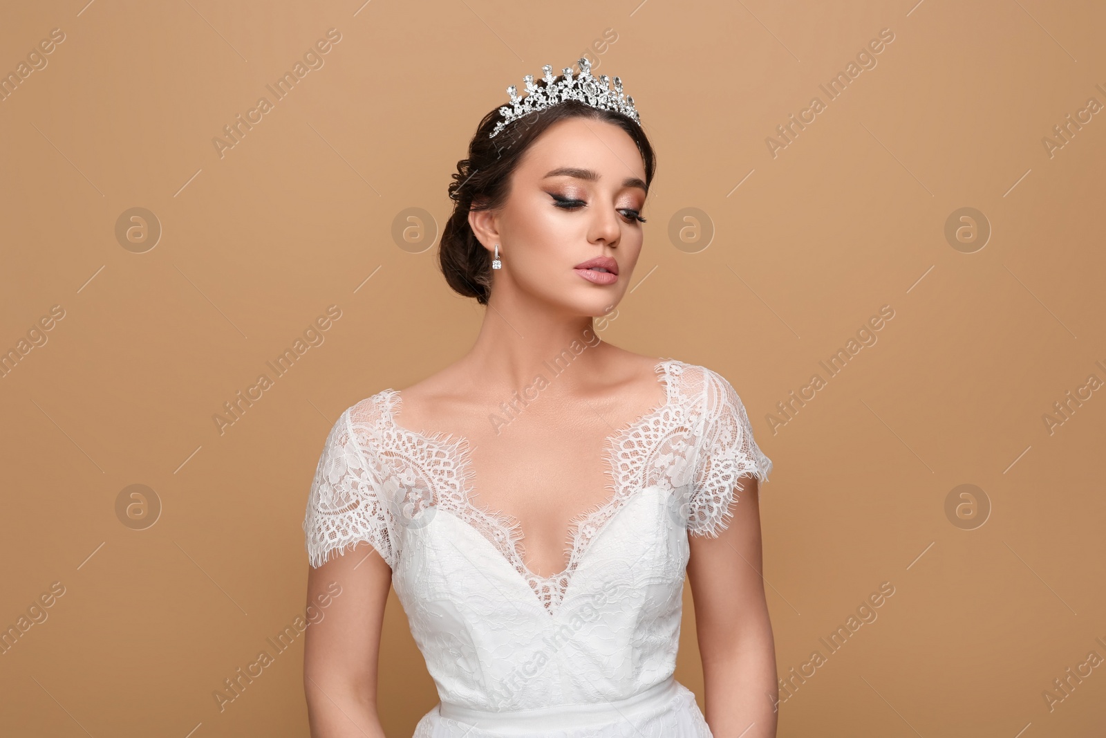 Photo of Beautiful young woman wearing luxurious tiara on beige background