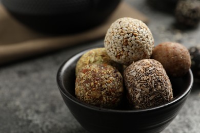 Delicious vegan candy balls on grey table, closeup