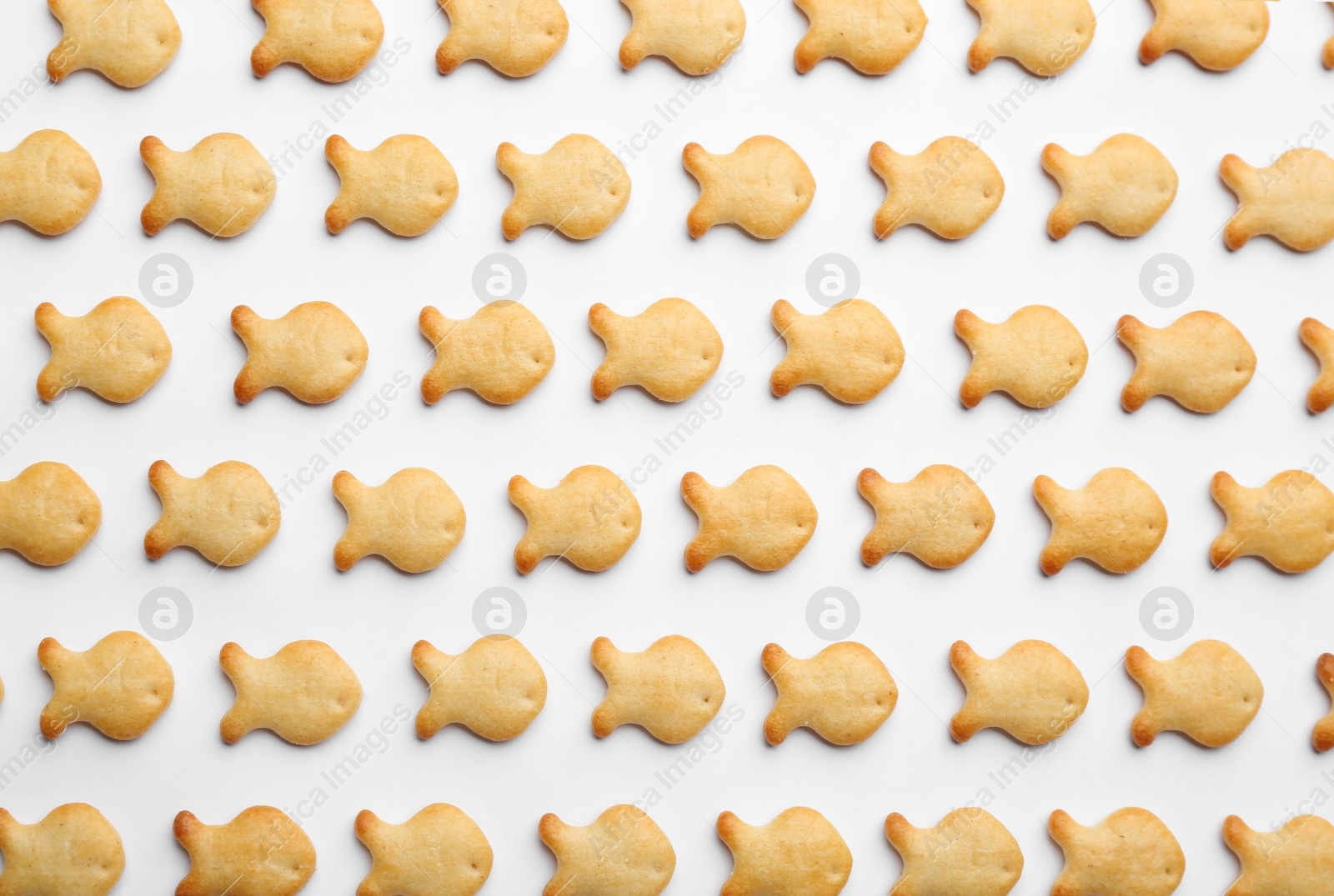 Photo of Delicious goldfish crackers on white background, top view