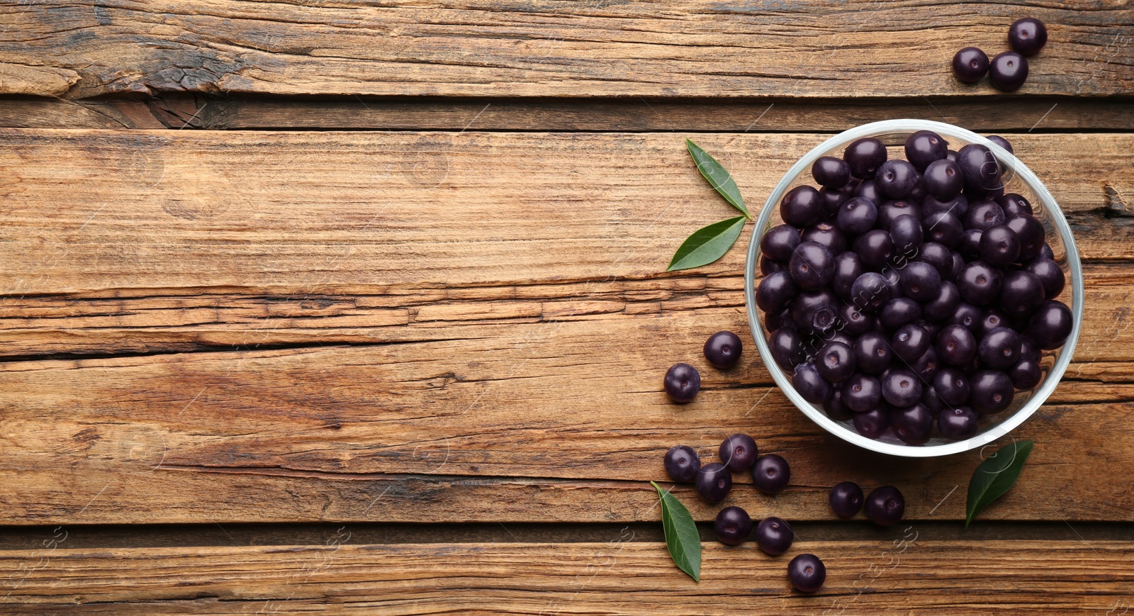 Photo of Fresh acai berries on wooden table, flat lay. Space for text