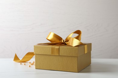 Beautiful golden gift box and decor on white table