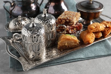 Photo of Tea, baklava dessert and Turkish delight served in vintage tea set on grey textured table, closeup