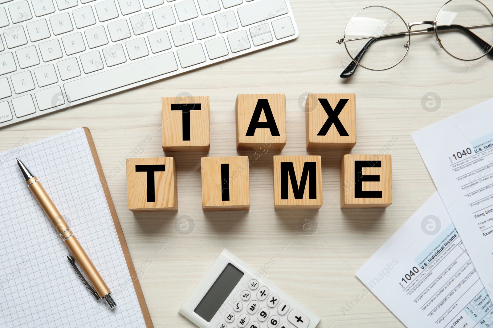 Photo of Cubes with words Tax Time, documents, keyboard, glasses and calculator on white wooden table, flat lay