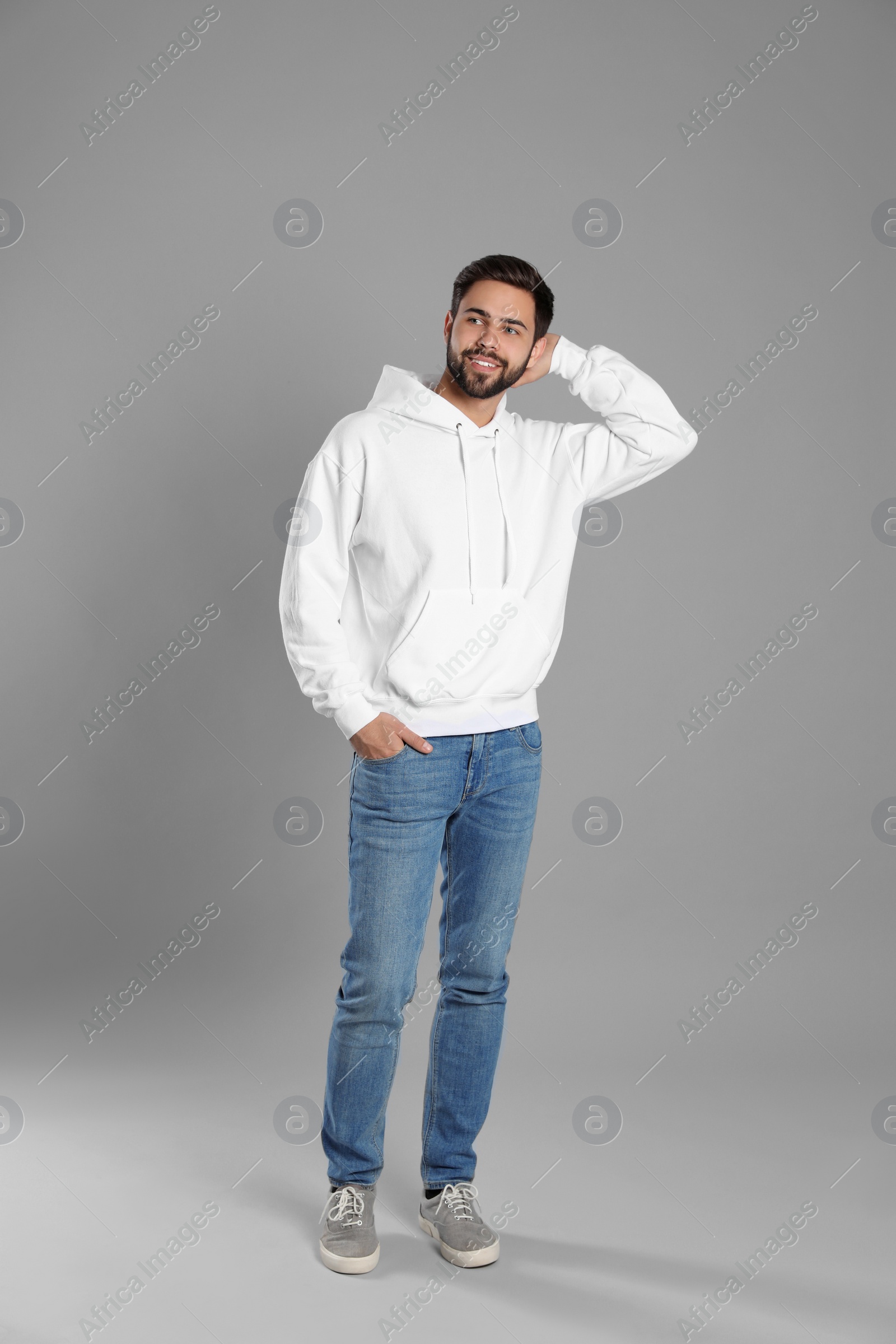 Photo of Full length portrait of young man in sweater on grey background. Mock up for design