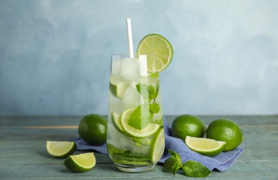 Delicious mojito and ingredients on blue wooden table