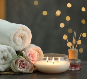 Composition with different spa products and rose flowers on grey table