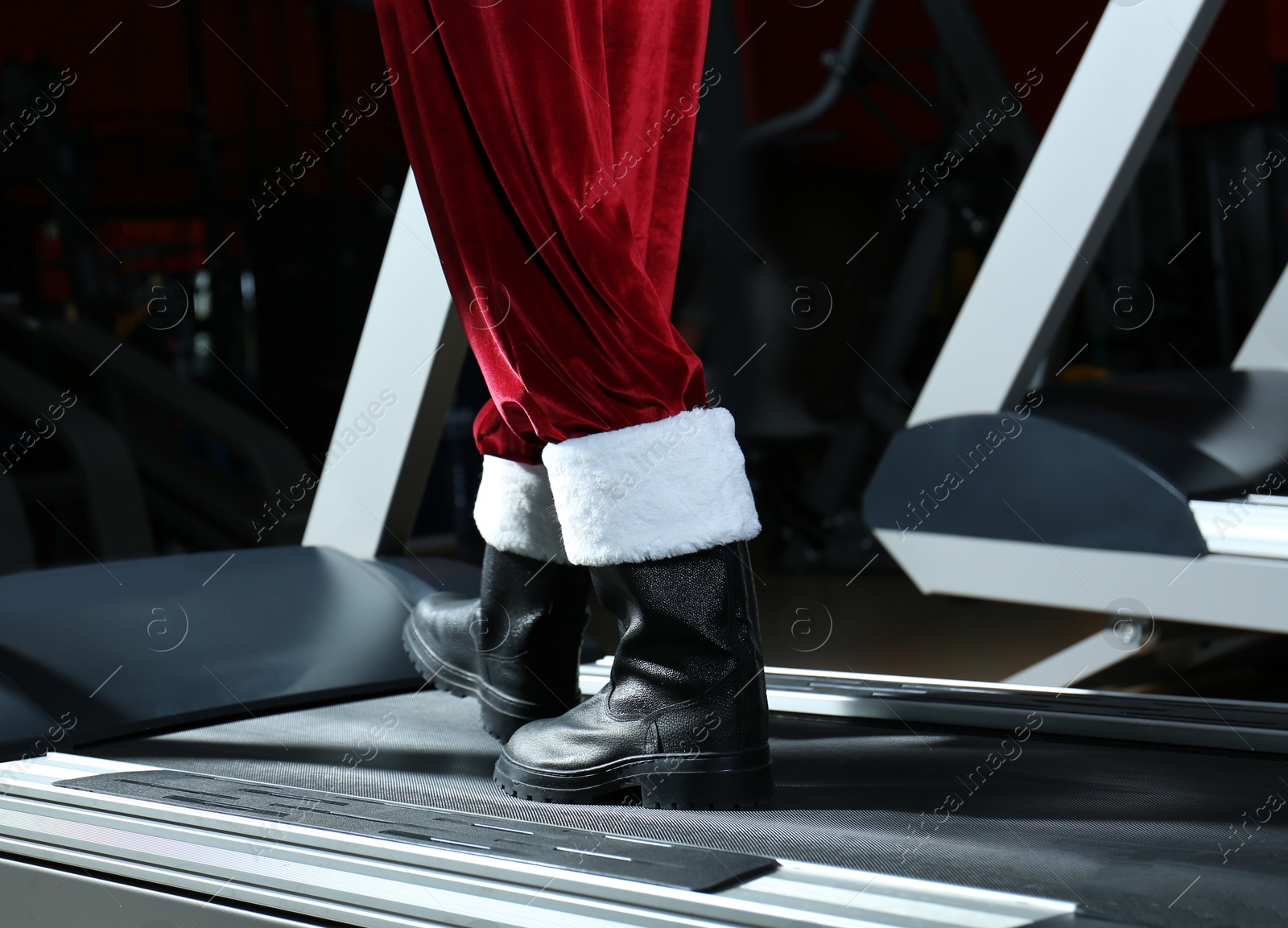 Photo of Authentic Santa Claus training on treadmill in modern gym