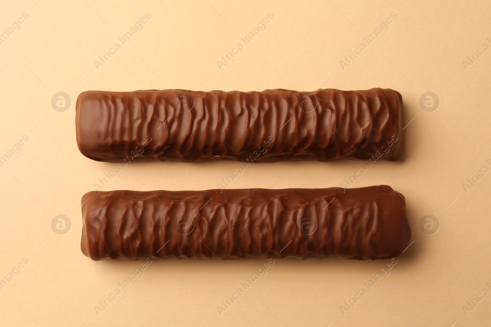 Photo of Sweet tasty chocolate bars on beige background, flat lay