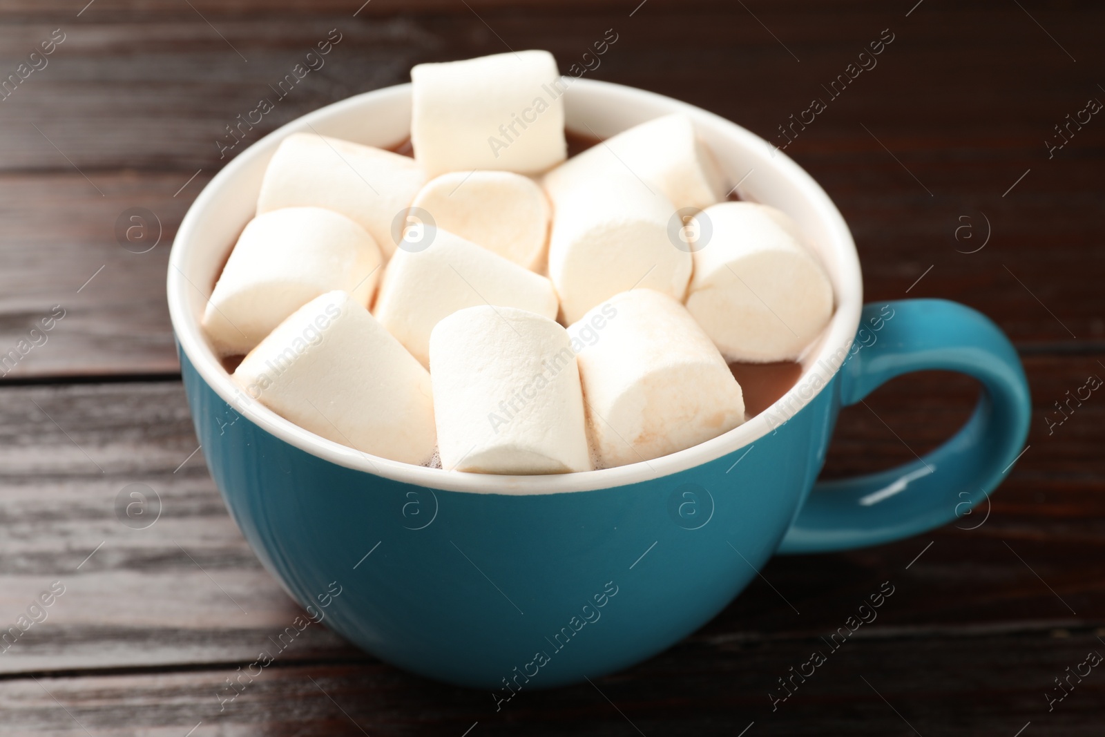 Photo of Tasty hot chocolate with marshmallows on wooden table, closeup