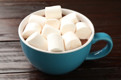 Photo of Tasty hot chocolate with marshmallows on wooden table, closeup