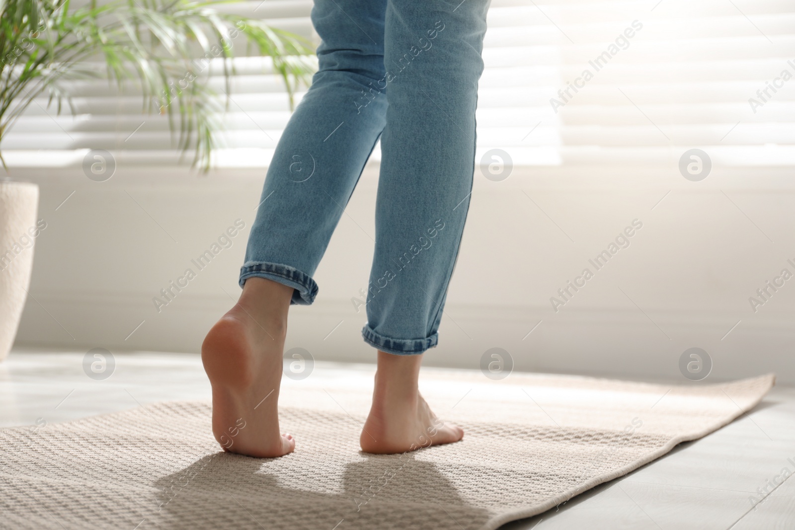 Photo of Woman standing on carpet at home, closeup