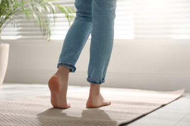 Photo of Woman standing on carpet at home, closeup