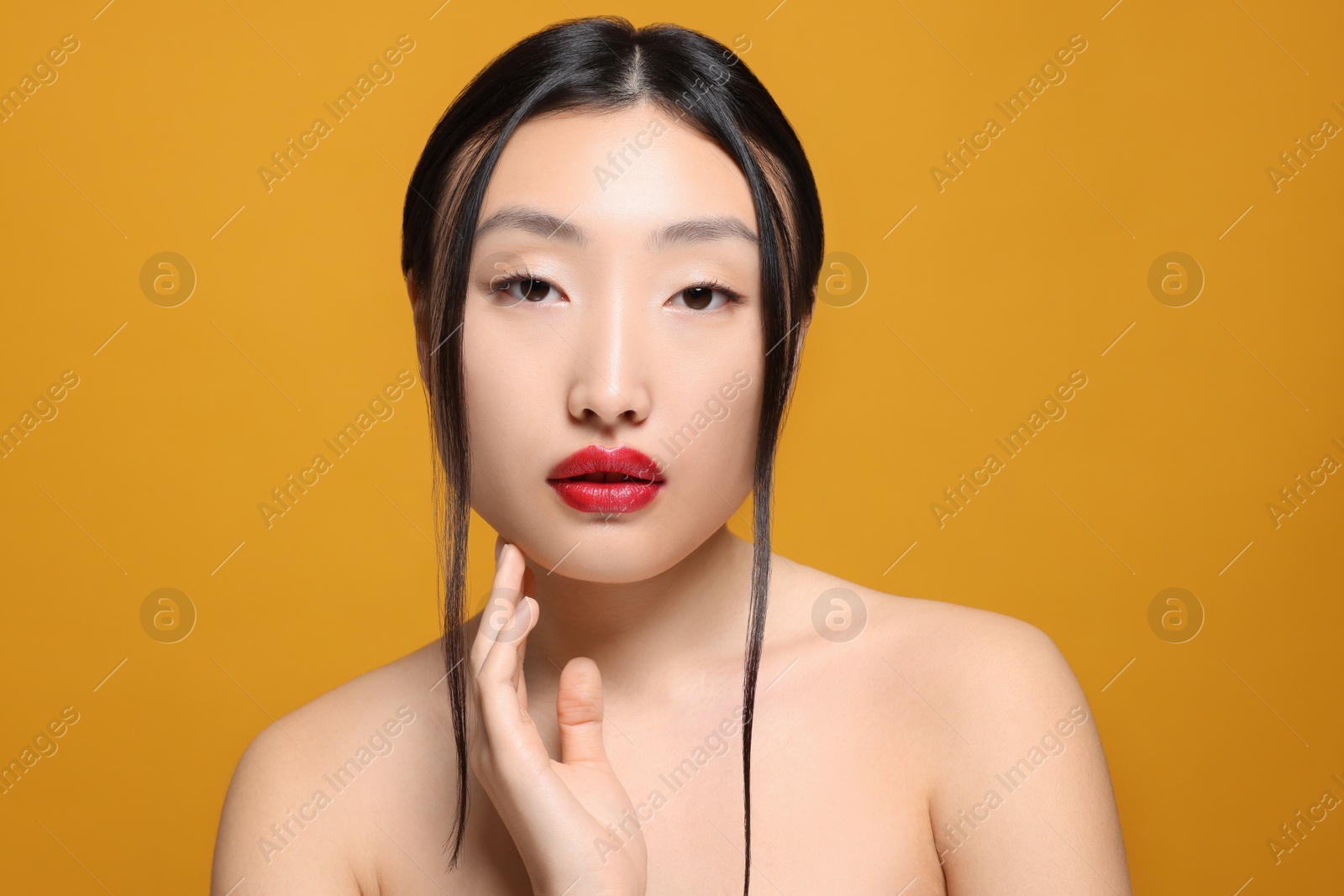 Photo of Portrait of beautiful young Asian woman on orange background