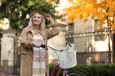 Photo of Mature woman with bicycle outdoors. Active lifestyle