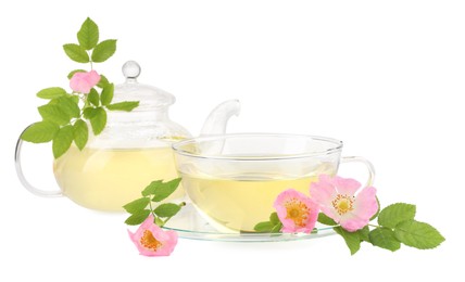 Aromatic herbal tea in glass cup, teapot, flowers and green leaves isolated on white