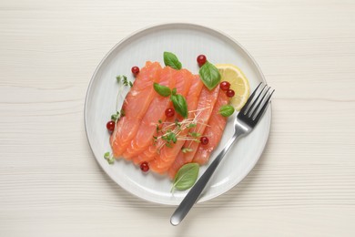 Delicious salmon carpaccio served on white wooden table, top view