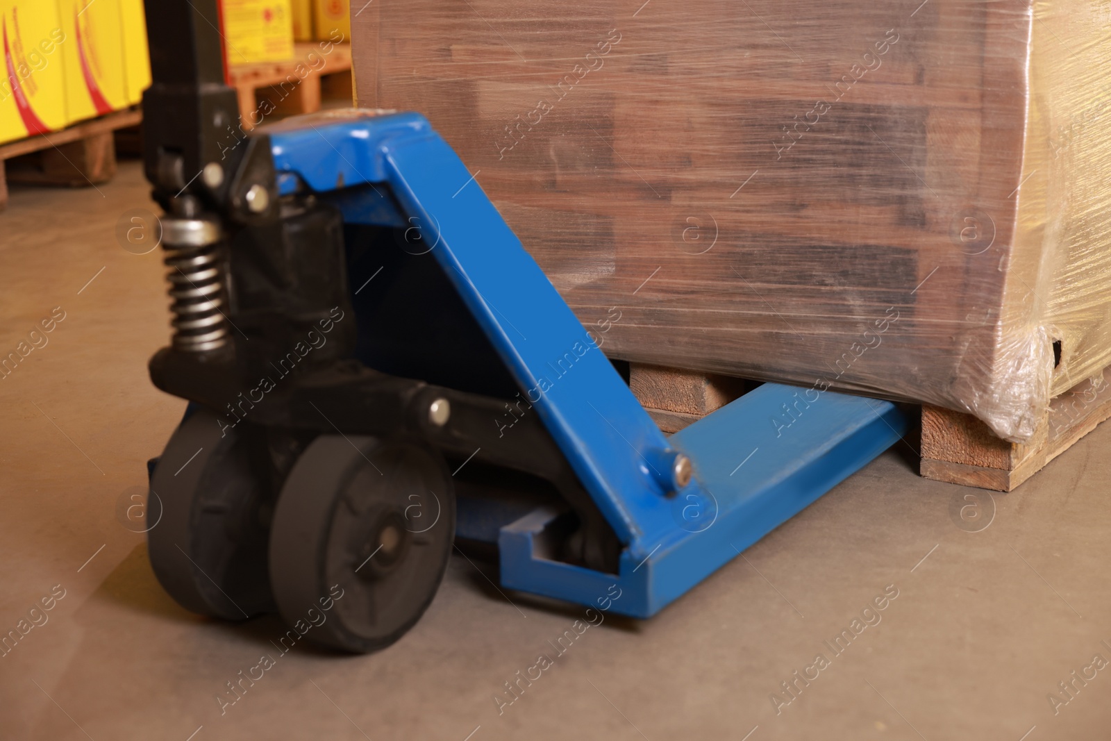 Image of Wooden pallets wrapped in stretch on manual forklift indoors, closeup