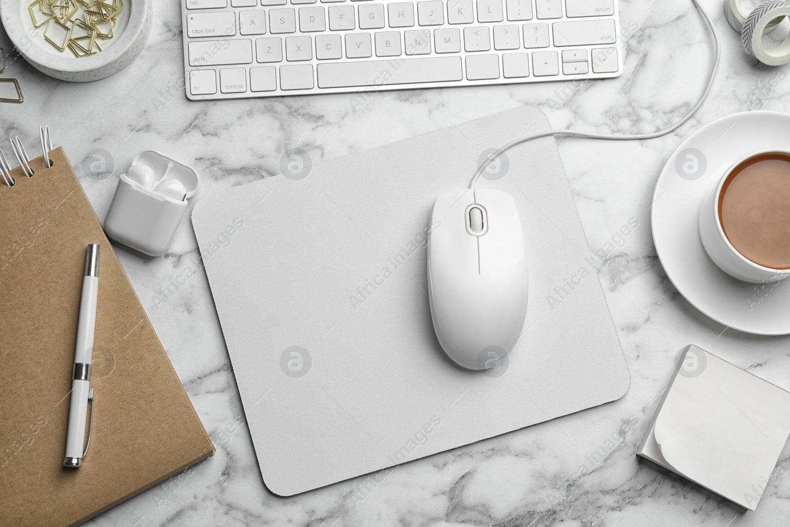 Photo of Modern workplace with mouse and keyboard on marble table, flat lay