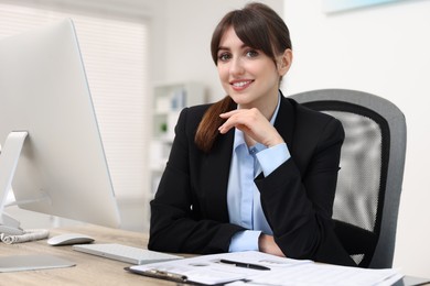 Photo of Portrait of smiling secretary at table in office