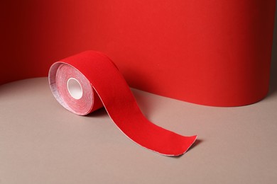 Photo of Bright kinesio tape in roll on color background